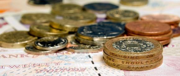 Coins laying on top of pound notes