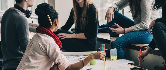 Group of students sitting around a table talking