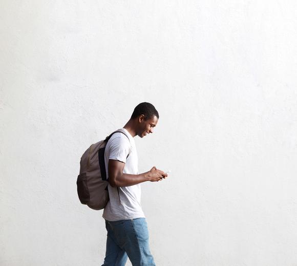 A student walking while using his phone