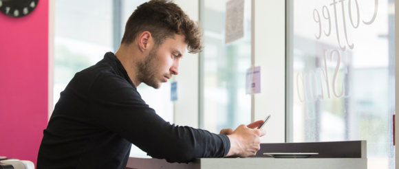 Student sitting and using their phone