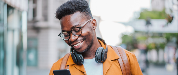 Student smiling at phone while walking