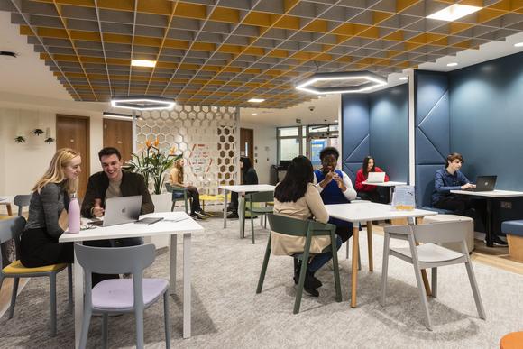 A photo of the inside of MySurrey Hive, showing students sitting at the tables and booths